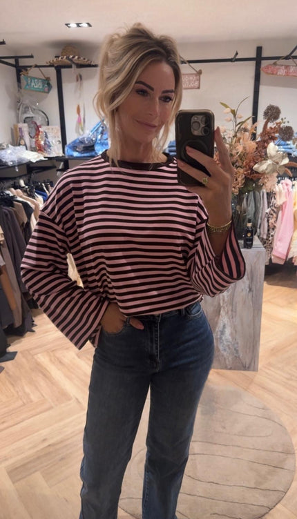 Model draagt gestreepte longsleeve zwart roze